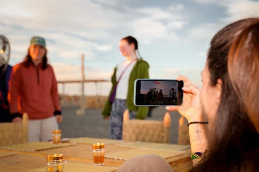 A person taking a photo of a group of people standing on a bridge. 1