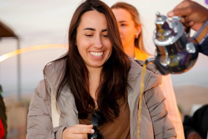 A person holding a camera, another person holding a fishing rod, and a tent in the background. 5