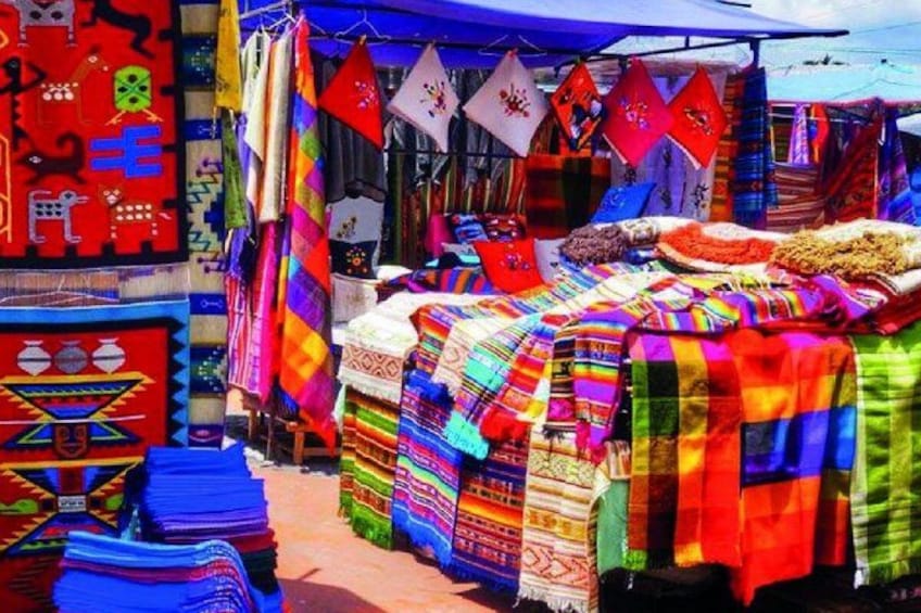A market stall with colorful textiles and blankets. 1