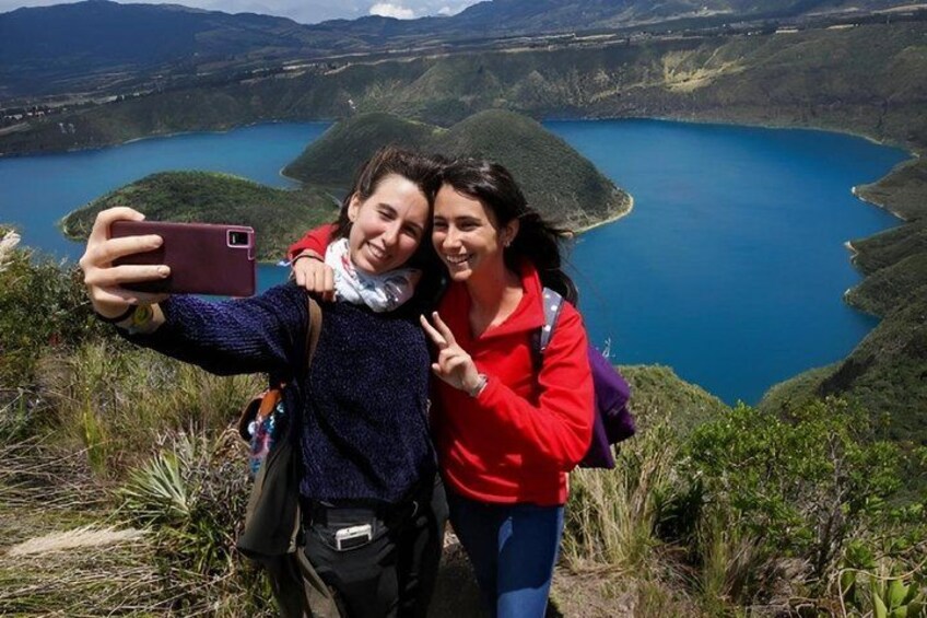 Two people taking a selfie with a lake and mountains in the background. 3