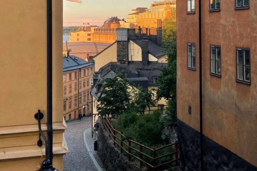 A street view with buildings, a cobblestone path, and a metal railing. 4