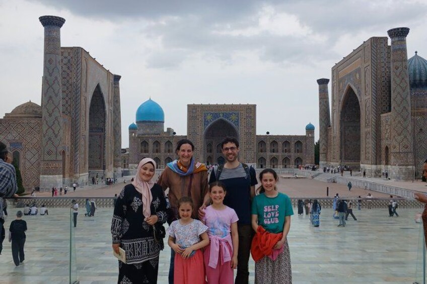 A group of people posing in front of a historic building with large domes and intricate tile work. 5