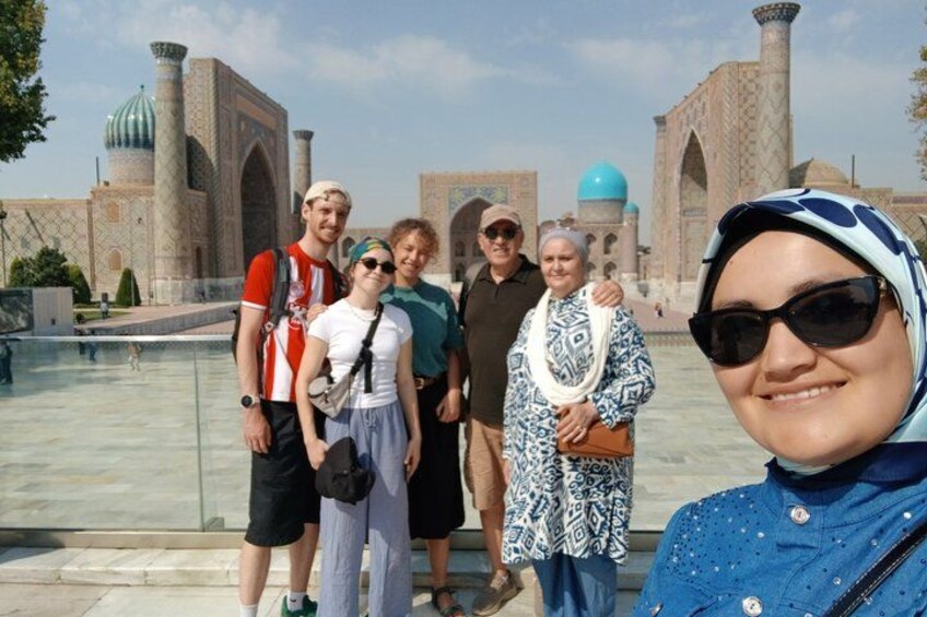 A group of people standing in front of a historical building with domed structures and arches. 3