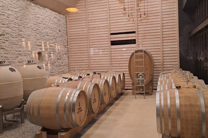 Wooden wine barrels in a room with stone walls and wooden slats. 3