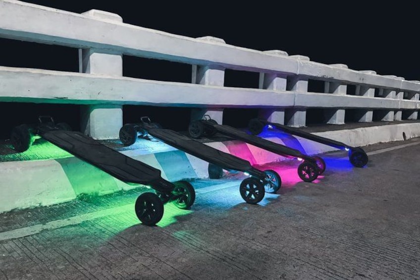 A series of aircraft on a concrete surface with colorful lighting. 5