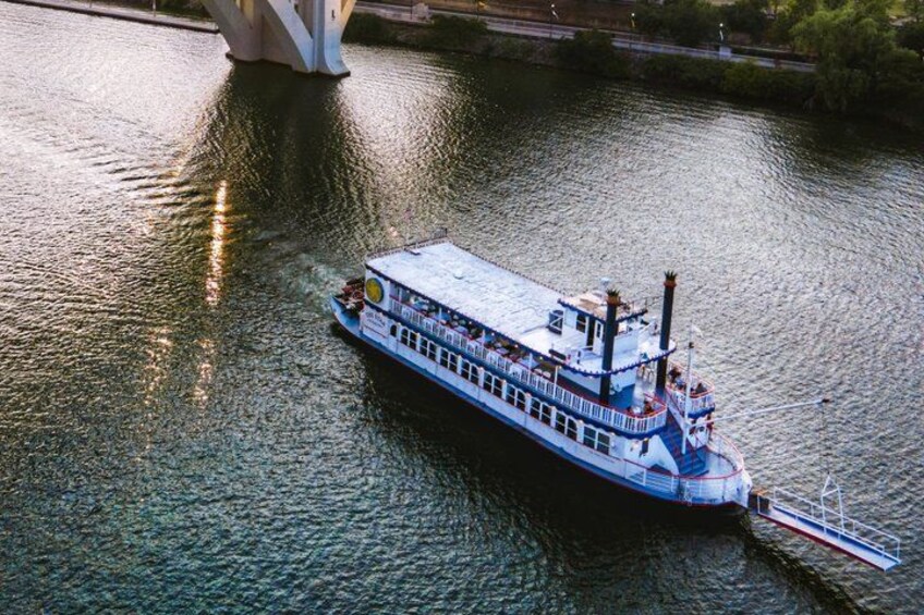 A riverboat with a blue and white color scheme, a covered upper deck, and a white lower deck. 1