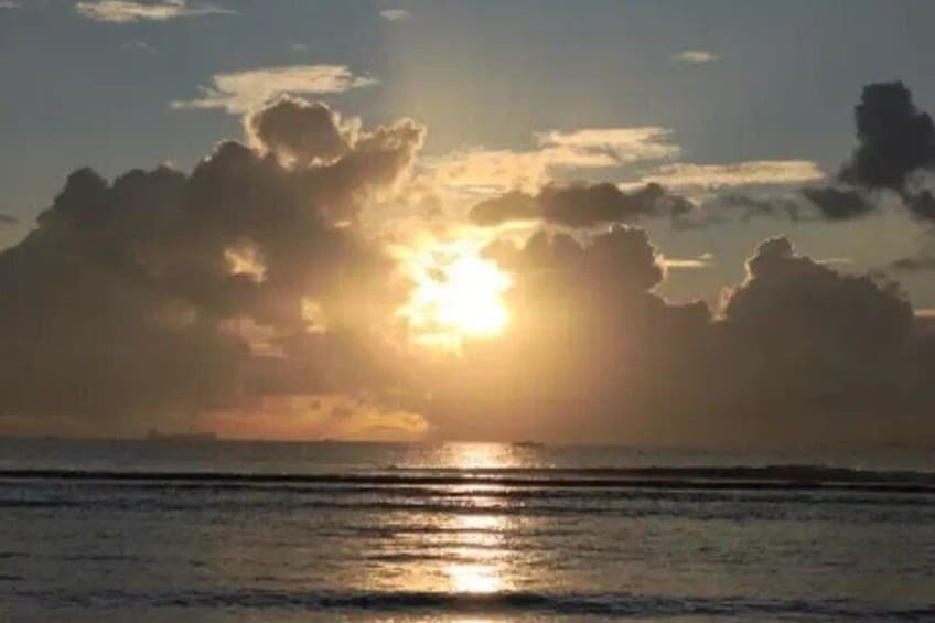 A sunset over a body of water with clouds reflecting the sunlight. 2