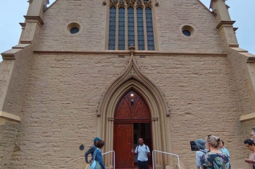 A church with a large wooden door and a pointed arch window. 2