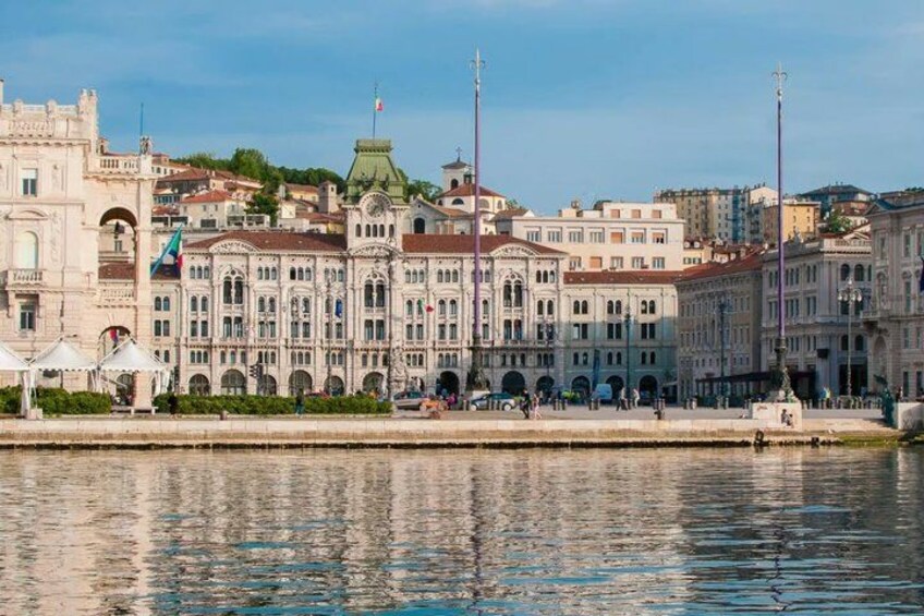A waterfront with historic buildings, a river, and a clear sky. 2
