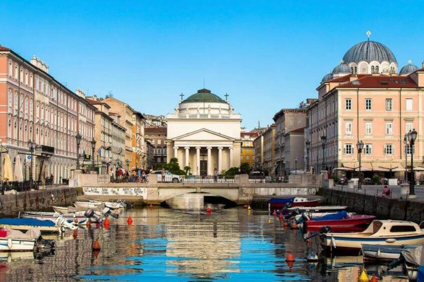 A canal with boats, a bridge, and classical architecture. 4
