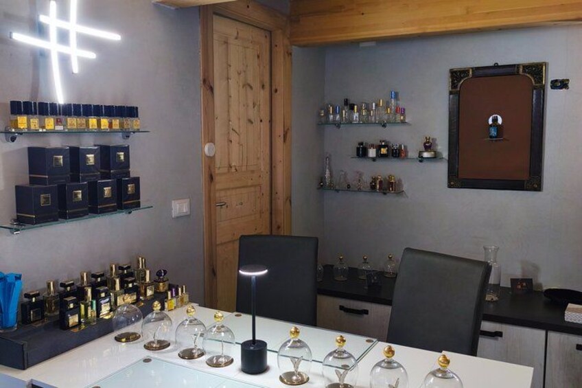 A room with shelves of bottles, a wooden door, and a table with wine glasses. 3