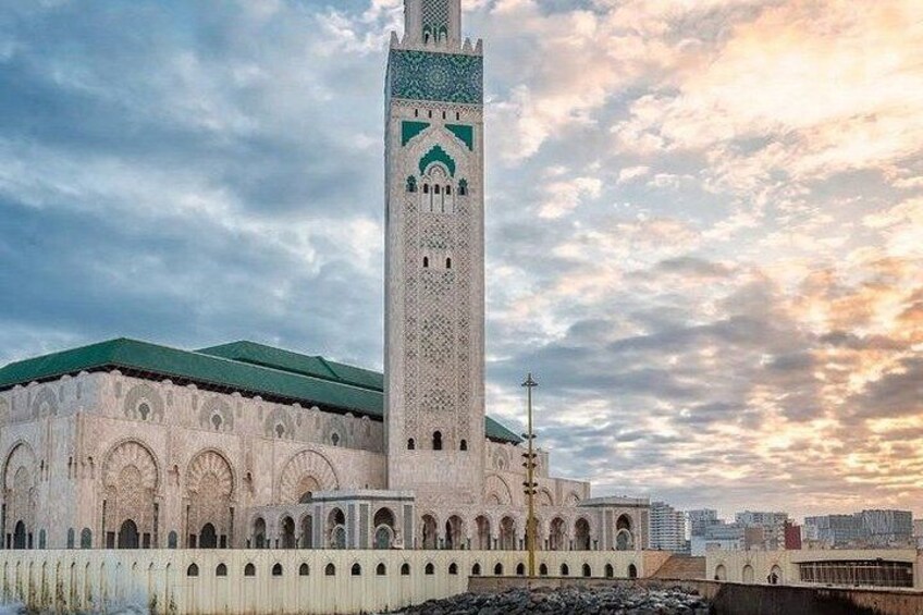 A large mosque with a tall minaret and a green roof. 2