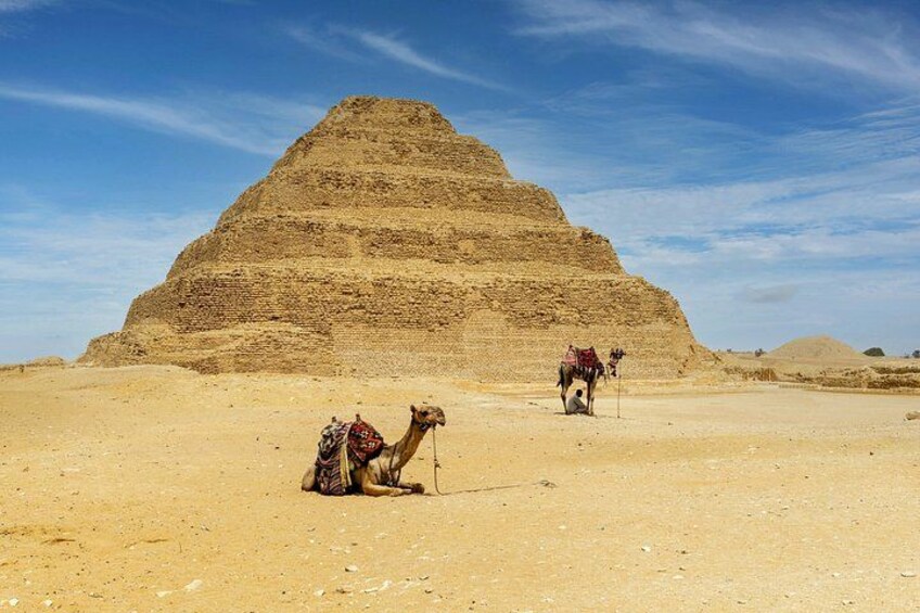 En pyramide i en ørken med kameler og en person. 2
