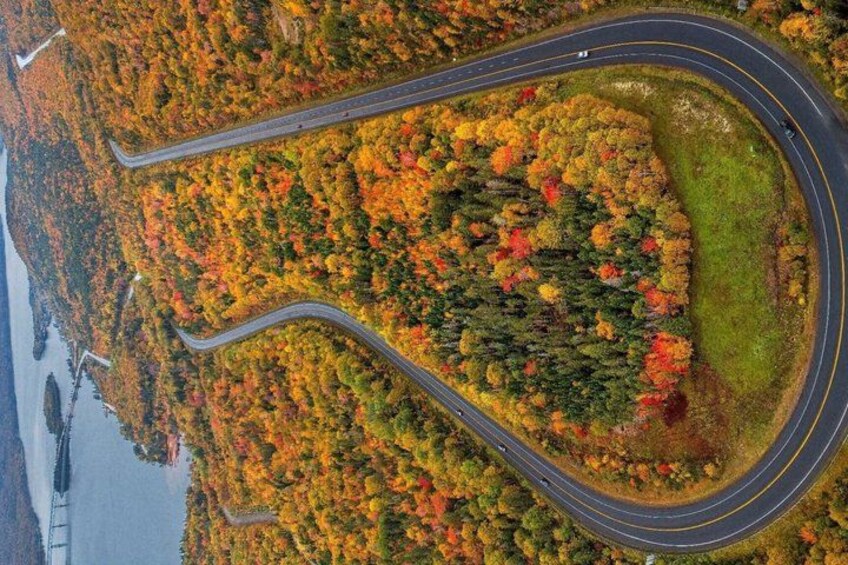 A winding road through a forest with autumn foliage. 2