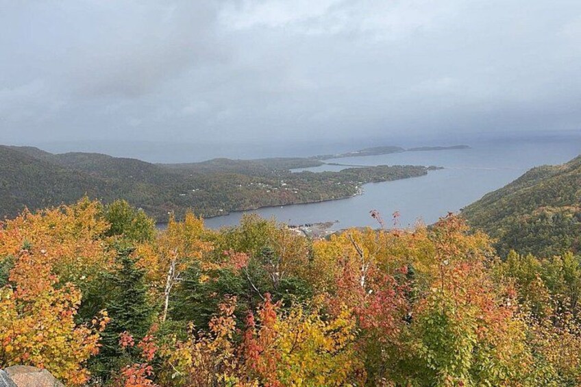 A mountainous landscape with autumn foliage, a lake, and distant islands. 5
