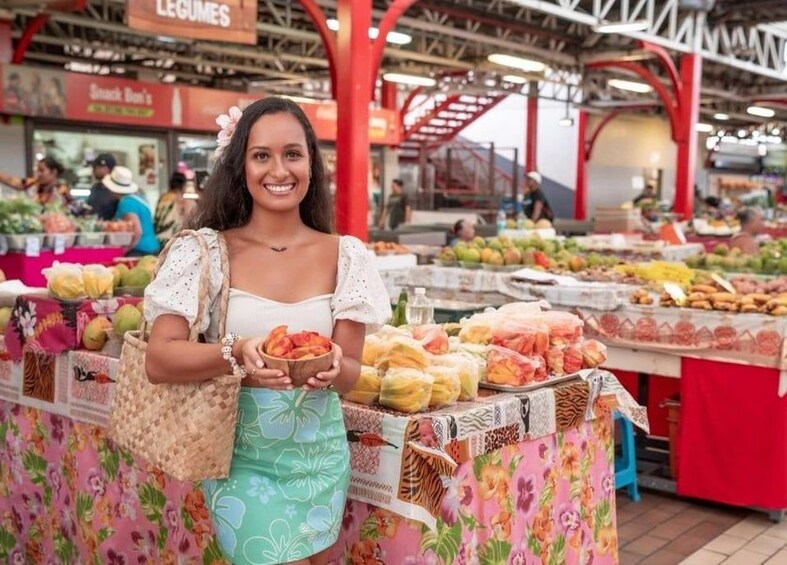 A person at a market stall with various fruits and vegetables. 1