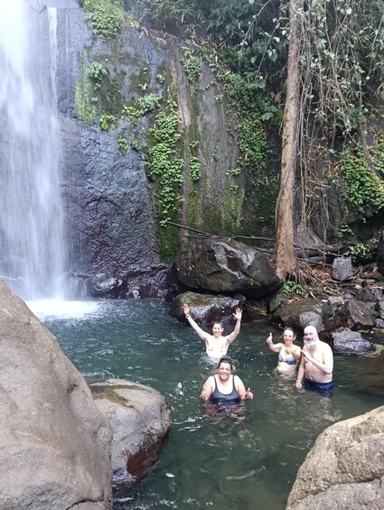 A waterfall, rocky terrain, and people in a natural setting. 1