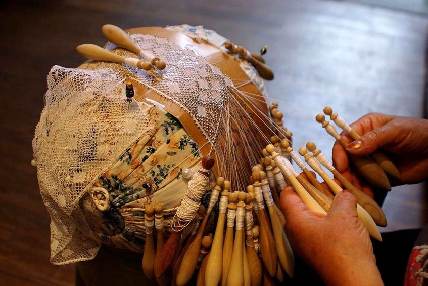 A person holding a stringed musical instrument with multiple strings and tuning pegs. 1