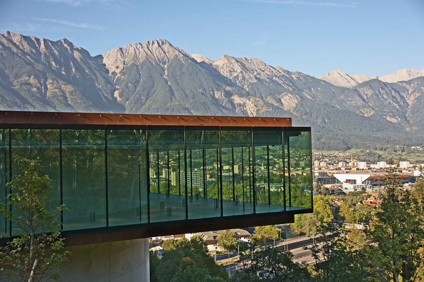 A modern glass structure with a mountain view. 2