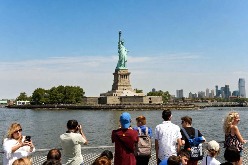 The Statue of Liberty with a river and city skyline in the background. 1
