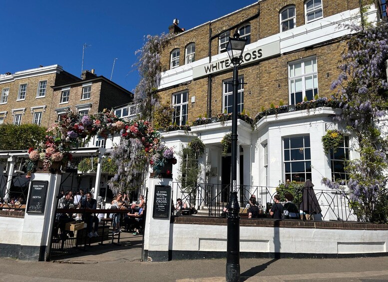 A pub named White Cross with outdoor seating and floral decorations. 4