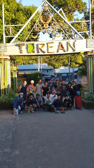 A group of people posing in front of a decorative archway with the word 'TURAN' visible. 3