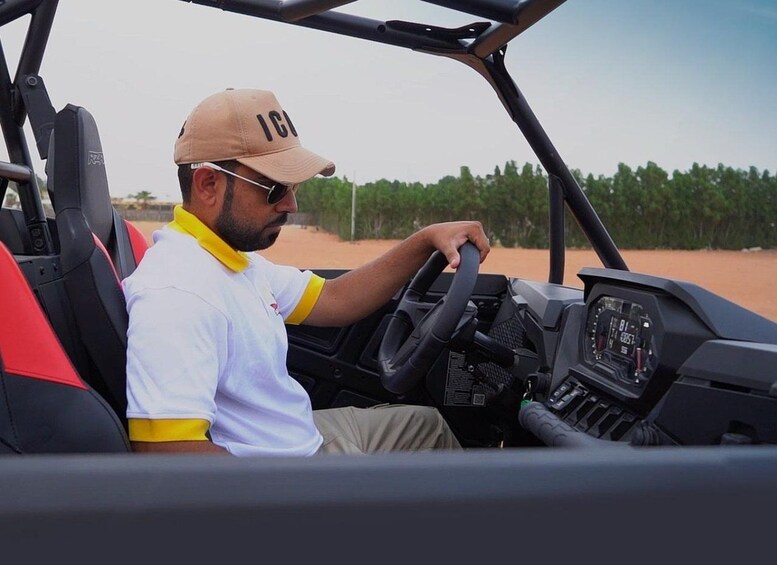 A person driving a vehicle with a steering wheel and dashboard. 3
