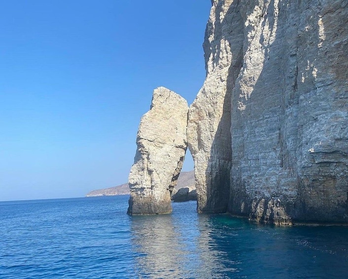 A coastal rock formation with a natural arch over the sea. 5