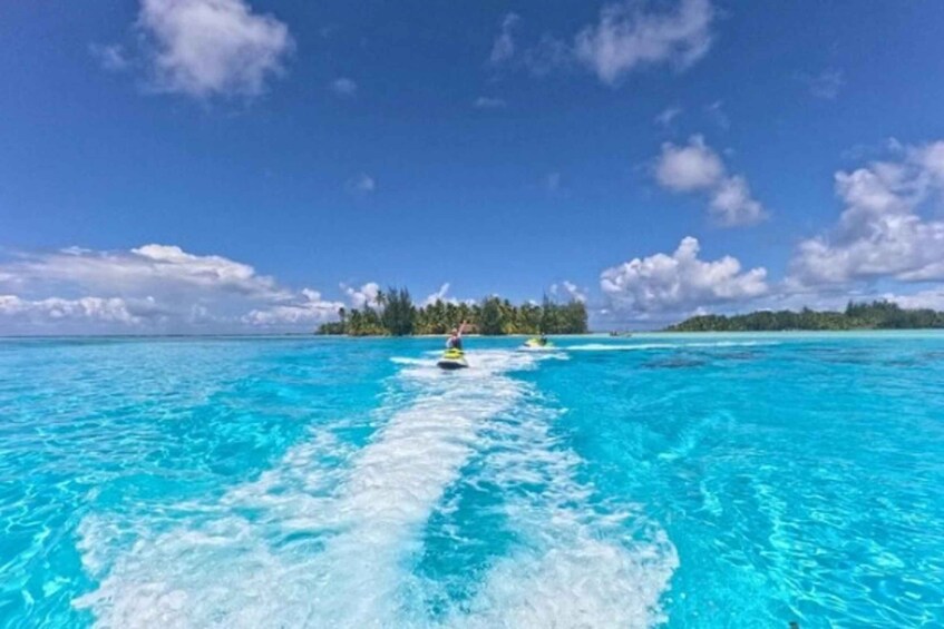 A clear blue sea with two jet skis creating a wake. 5