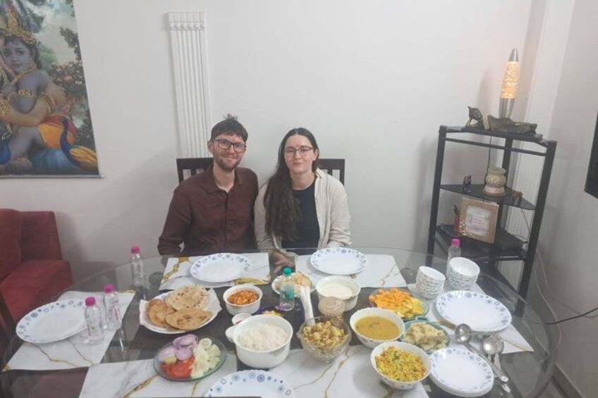 Two people seated at a table with various dishes. 2