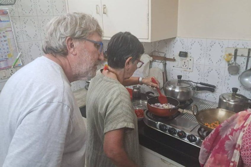 A kitchen with a stove, pots, and a person cooking. 3