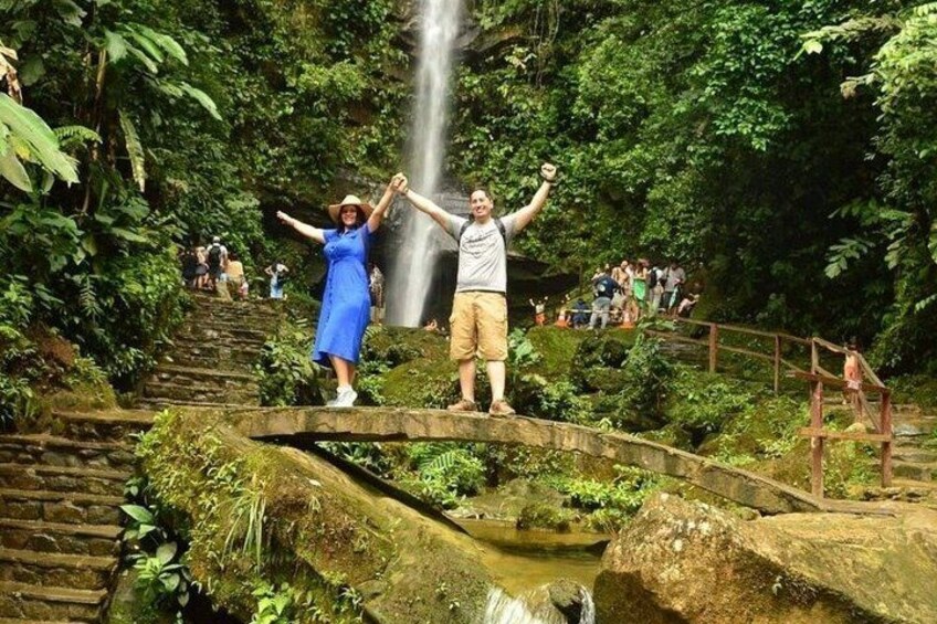 A waterfall, a stone bridge, and lush greenery. 4