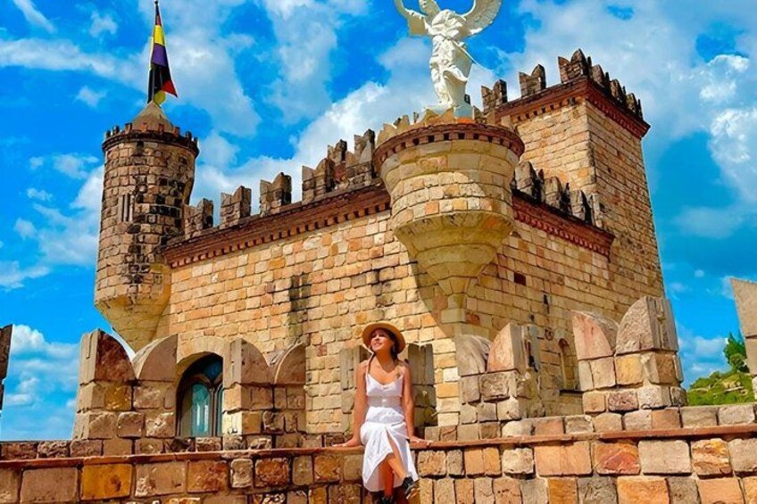 A castle with a tower, a statue, and a flag. 4