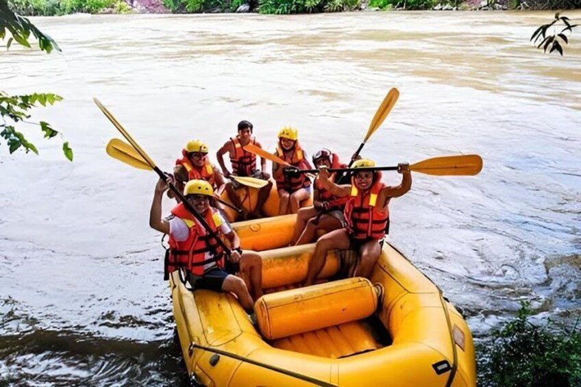 A group of people in a yellow raft on a river, wearing life jackets and helmets. 2