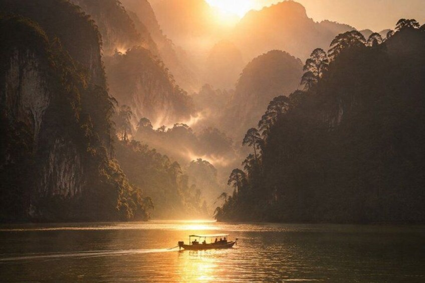 A boat on a river surrounded by mountains during sunrise. 1
