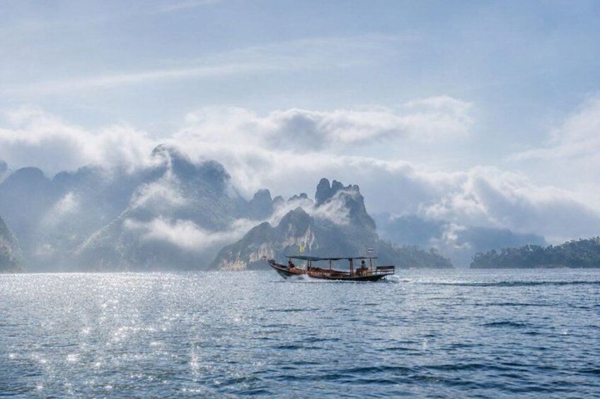 A boat on calm water with mountains in the background. 2