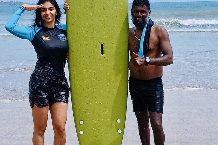 A woman and a man standing on a beach holding a surfboard. 3