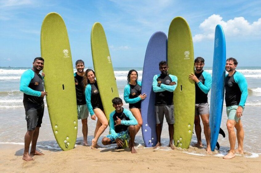 A group of people on a beach holding surfboards. 1