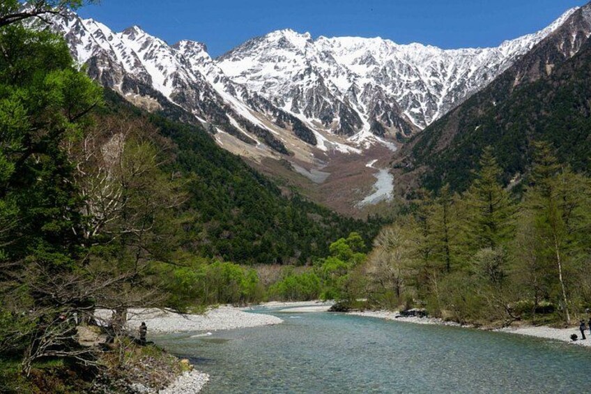 A river flowing through a valley with snow-capped mountains in the background. 3