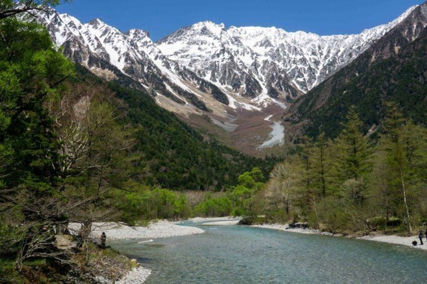A river flowing through a valley with snow-capped mountains in the background. 3