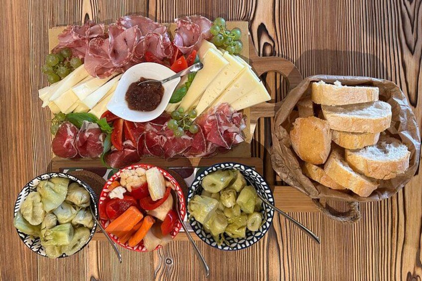 A charcuterie board with various meats, cheeses, and pickles. 4