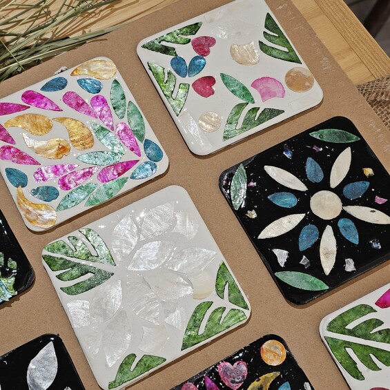 A collection of painted tiles with various leaf and flower designs. 4