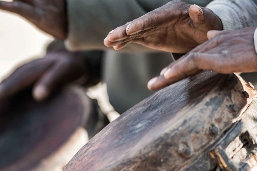 Hands resting on a wooden surface. 1