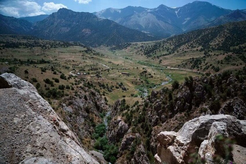 A mountainous landscape with a valley, rocky outcrops, and a river. 2
