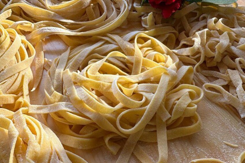 A pile of yellow pasta on a surface. 2
