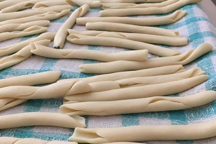 Uncooked pasta dough laid out on a checkered cloth. 1