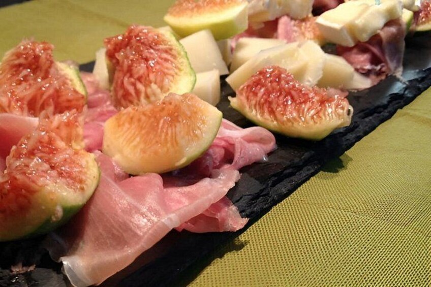 A charcuterie board with sliced figs, cheese, and cured meats. 2