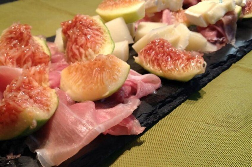 A charcuterie board with sliced figs, cheese, and cured meats. 2