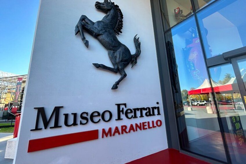 A sign for Museo Ferrari Maranello with a horse logo. 1