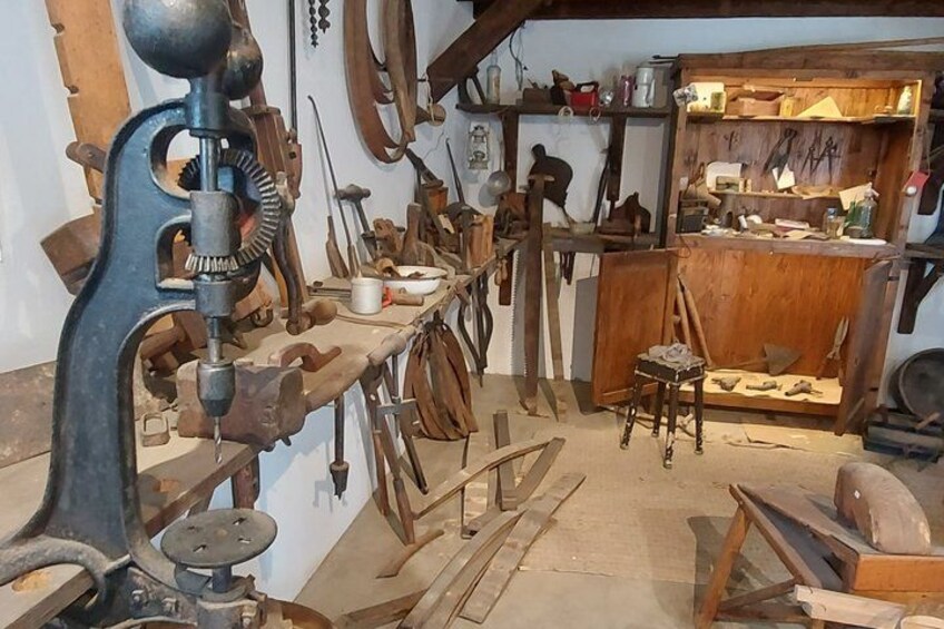 A workshop with tools and equipment, including a large drill press and various woodworking tools. 2